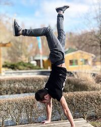 Full length of man doing handstand on table