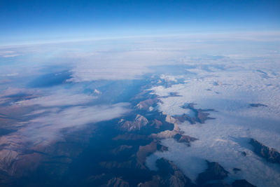 Aerial view of snowcapped landscape against sky