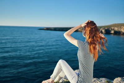 Woman standing in sea against sky