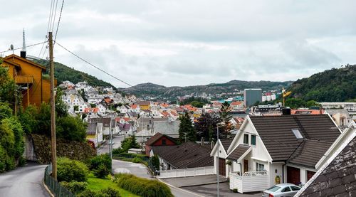 Houses in town against cloudy sky