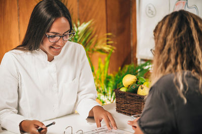 Dietician explaining nutritional facts label to client at weight loss clinic