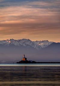 Scenic view of sea and mountains against sky during sunset