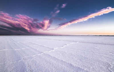 Scenic view of snow covered landscape at sunset