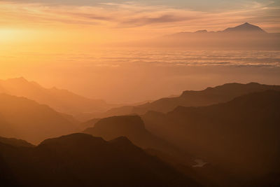 Scenic view of silhouette mountains against sky during sunset