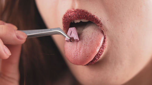 Close-up of woman eating alphabet with hand tool