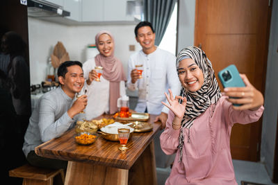 Female friends using mobile phone while sitting on table