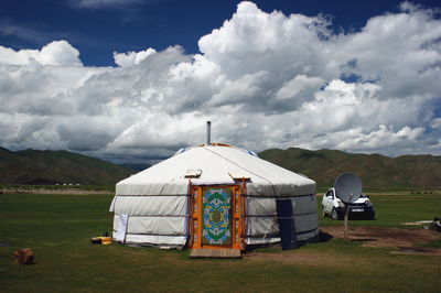 Built structure on field against sky