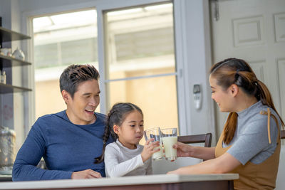 Happy friends sitting on table