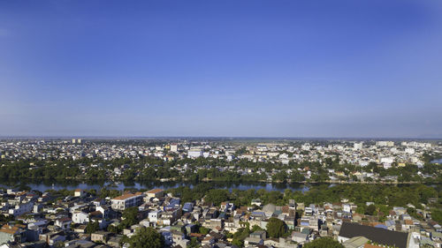 High angle view of townscape by sea against clear sky