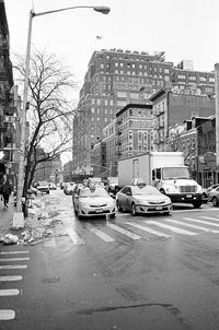 Cars on city street against clear sky