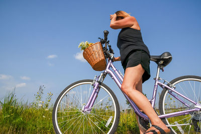 Man riding bicycle in basket against sky