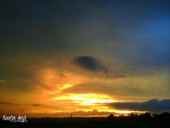 Low angle view of silhouette trees against dramatic sky