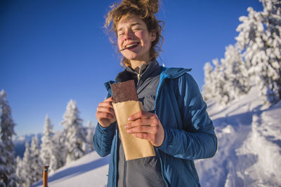 Young woman smiling and eating chocolate in the sun