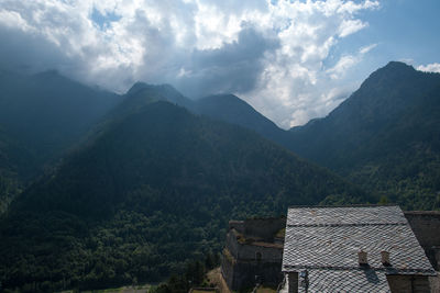 Scenic view of mountains and houses against sky