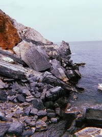 Rocks on beach against clear sky