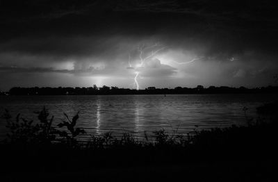 Scenic view of lake against sky at night