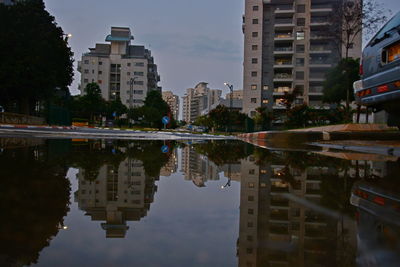 Reflection of buildings in puddle on lake