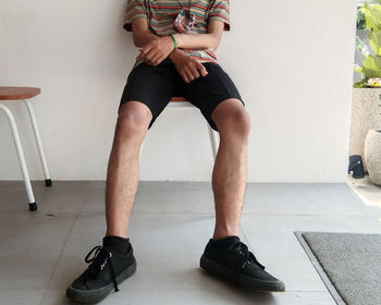 Low section of man sitting on tiled floor