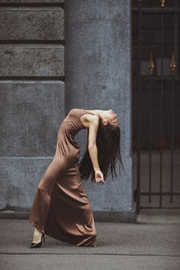 Rear view of woman standing against wall