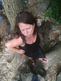High angle view of smiling young woman on rock