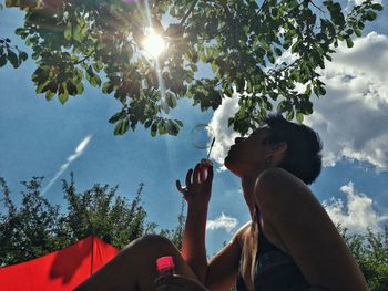 Low angle view of tree against sky on sunny day