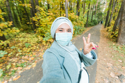 Portrait of young woman standing in forest