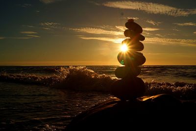 Silhouette woman on beach against sky during sunset