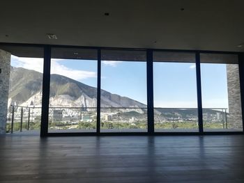 Scenic view of mountains against sky seen through window