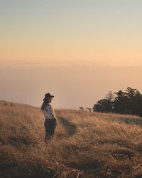 Full length of man standing on field against sky during sunset