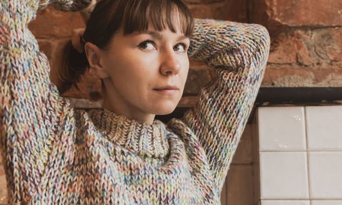 Close-up of woman looking away while standing against wall