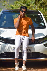 Portrait of young man standing in car