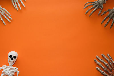 Close-up of human hand against orange wall