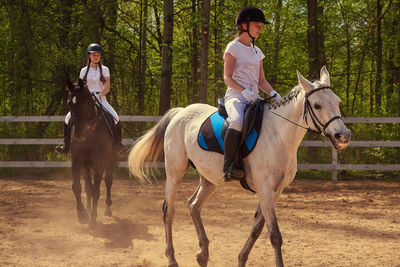 Females horseback riding at ranch