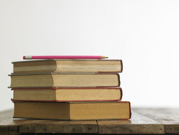 Close-up of stacked books on table against white background