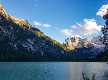 Scenic view of lake by mountains against sky