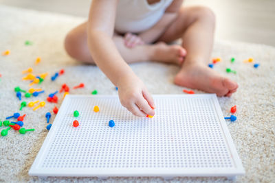 Low section of girl playing with toy at home