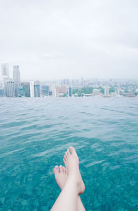 Low section of person relaxing at city waterfront