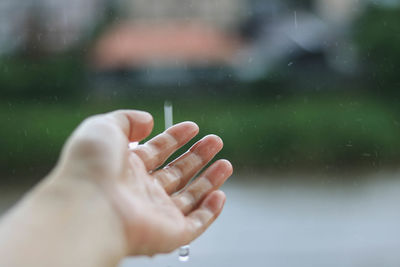 Close-up of woman hand against blurred water