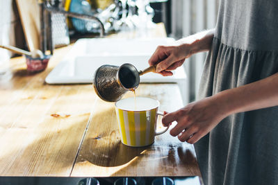 Woman holding coffee cup on table