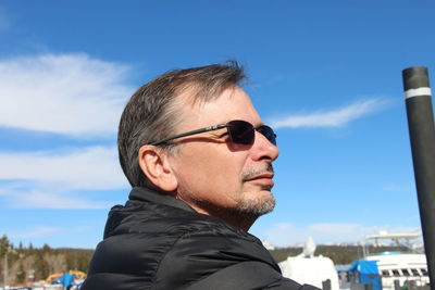 Close-up of thoughtful man looking away against sky