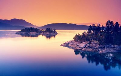 Scenic view of lake against clear sky during sunset