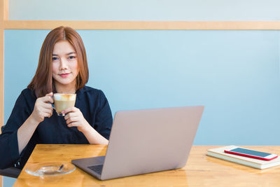 Young woman using laptop on table