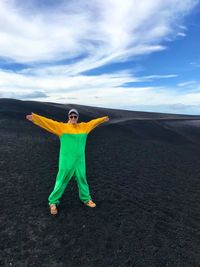 Woman in protective workwear standing on mountain against sky