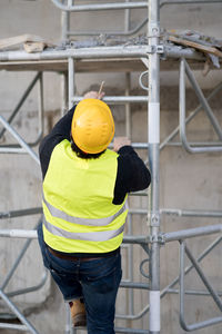Construction worker climbing on scaffolding