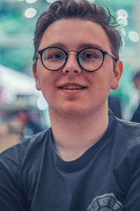 Portrait of smiling young man wearing eyeglasses outdoors