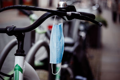 Close-up of bicycle hanging on rack in city