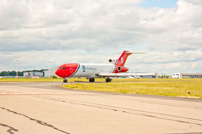 Airplane on runway against sky