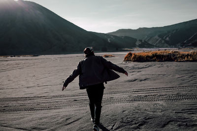 Rear view of man standing on shore