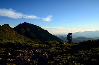 Man hiking on mountain against sky