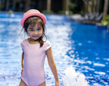 Portrait of cute girl standing in swimming pool